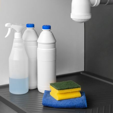 Tapis de protection pour fond de meuble cuisine, avec éponges et bouteilles de nettoyage à proximité, image montrant le dessous