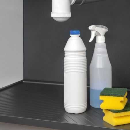 Tapis de protection pour fond de meuble de cuisine sous évier, anthracite, avec flacons et éponges scolaires au premier plan.