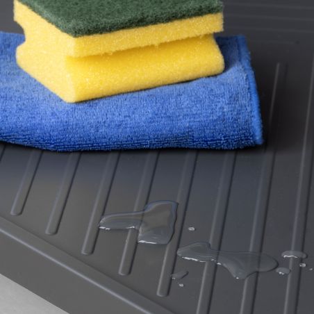 Tapis de protection Sink pour fond de meuble de cuisine anthracite avec éponges et eau, vue du plateau noir.