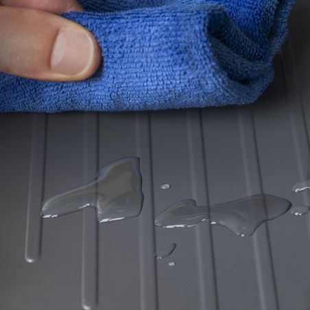 Tapis de protection Sink essuyant des traces d’eau sur un fond de meuble de cuisine anthracite.
